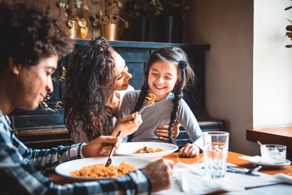 Family eating pasta together at a restaurant